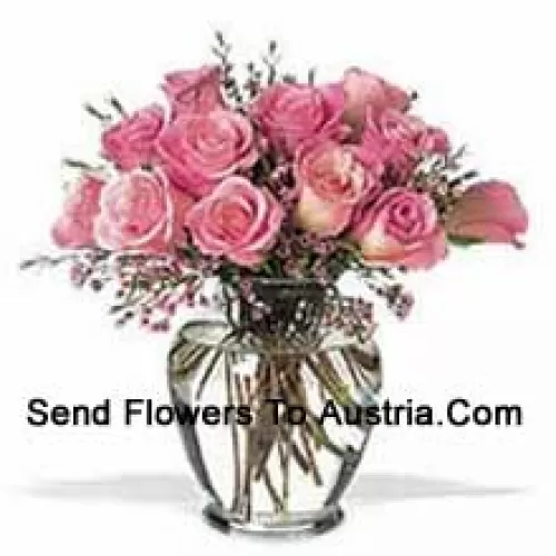 Bouquet de 11 roses roses avec quelques fougères dans un vase