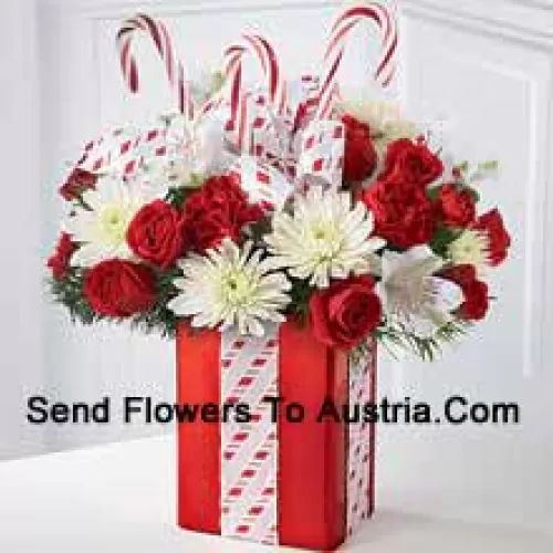 This Bouquet will dazzle them with its whimsical joy and spirited beauty! A gorgeous arrangement of white mums, red carnations and spray roses sit amongst holiday greens in a shiny red vase adorned with candy canes and wrapped to perfection with a beautiful bow, making it look like the finest holiday gift. (Please Note That We Reserve The Right To Substitute Any Product With A Suitable Product Of Equal Value In Case Of Non-Availability Of A Certain Product)